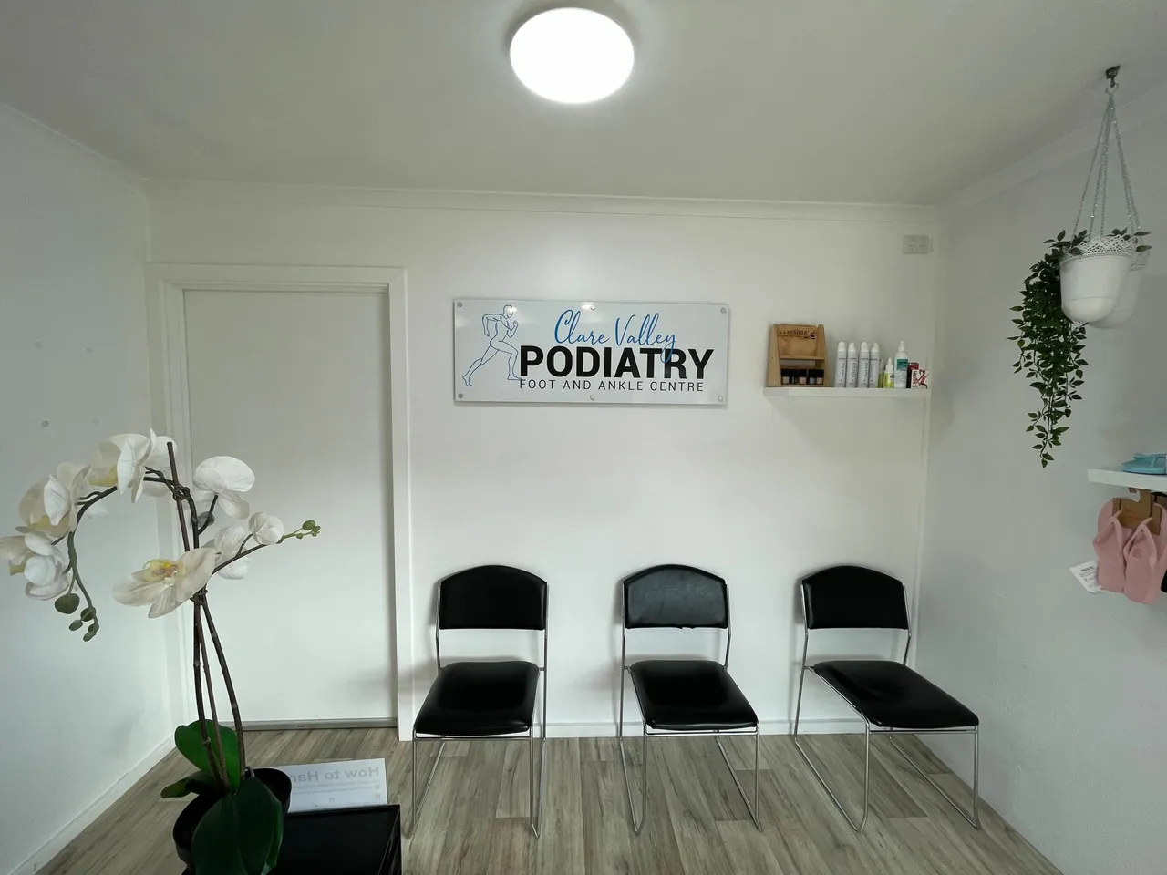The clinic's bright reception and waiting area with three chairs beneath a Clare Valley Podiatry sign